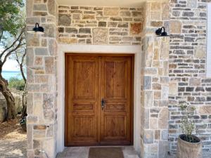 a stone building with a wooden door in front at Villa Riba in Lun