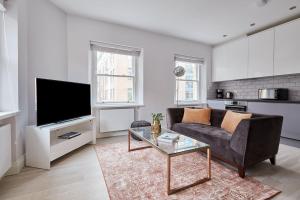 un soggiorno con divano e TV di 6VH Virginia House, 31 Bloomsbury Way By City Living London a Londra