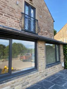 a reflection of a fire truck in the windows of a brick building at Naze View Barn - Cosy, with all mod cons in Whaley Bridge