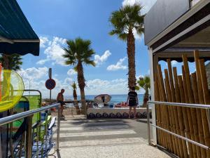 a woman walking on the beach with palm trees at Estudio Calafin 56 in Finestrat