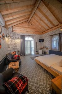ein Schlafzimmer mit einem großen Bett und Stühlen in einem Zimmer in der Unterkunft Pino Mar Luxury Bungalows in Erdek