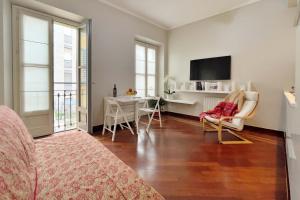 sala de estar con TV y mesa con sillas en Chic Apartment in San Babila, en Milán