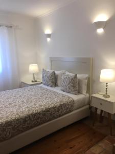 a hotel room with a bed and a lamp at Guarda Rios in Vila Nova de Milfontes