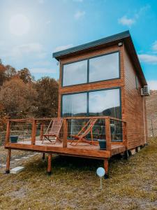 une petite maison avec une grande fenêtre sur un champ dans l'établissement Roua by NorAtlas Heritage - Adults Only, à Buzău