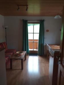ein Wohnzimmer mit einem Sofa, einem Tisch und einem Fenster in der Unterkunft Fronwieshäusl Gschoßmann Herbert in Ramsau bei Berchtesgaden