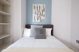 a bed with white sheets and a pillow on it at 4VH Virginia House, 31 Bloomsbury Way By City Living London in London