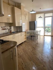 a kitchen with white cabinets and a table with chairs at Затишні апартаменти in Chernivtsi