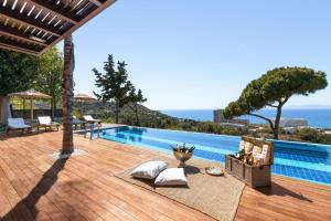 una piscina con terraza de madera y el océano en Villa Equinox, en Ixia