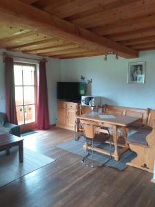 ein Wohnzimmer mit einem Holztisch und einer Küche in der Unterkunft Fronwieshäusl Gschoßmann Johanna in Ramsau bei Berchtesgaden