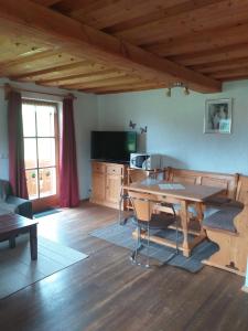 a living room with a wooden table and a kitchen at Fronwieshäusl Gschoßmann Johanna in Ramsau