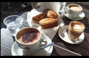 a table with two cups of coffee and some bread at Dei Due Portoni Suite Storica in Lecce