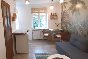 a living room with a blue couch and a table at Lemuria Apartament Szkolna centrum in Legnica