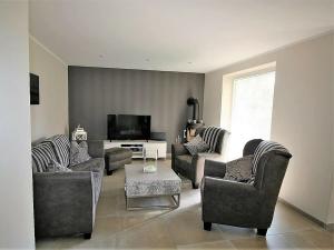 a living room with couches and a flat screen tv at Ferienhaus Küstenhaus Wremen in Wremerbüttel