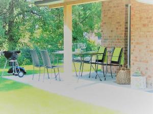 a patio with a table and chairs and a grill at Ferienhaus Küstenhaus Wremen in Wremerbüttel