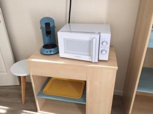 un microondas sobre una mesa de madera en Chambre dans dépendance Maison de Ville + abri vélos, en Saumur