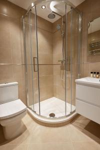 a bathroom with a shower and a toilet and a sink at 7VH Virginia House, 31 Bloomsbury Way By City Living London in London