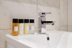 a bathroom sink with three bottles of essential oils on it at 7VH Virginia House, 31 Bloomsbury Way By City Living London in London