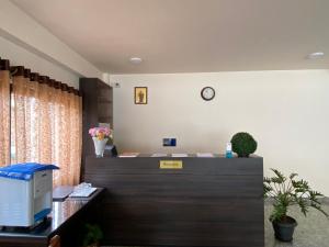 ein Büro mit einer Rezeption und einer Uhr an der Wand in der Unterkunft The Arbour Inn in Shillong