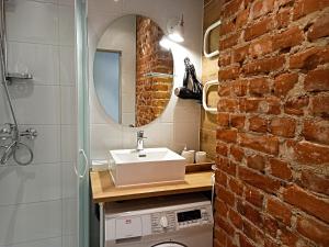 a bathroom with a sink and a brick wall at Klaipeda city center apartment in Klaipėda