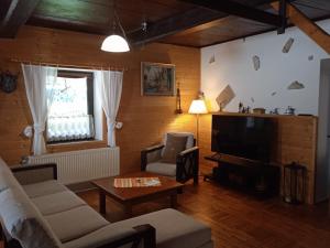 a living room with a couch and a television at Chalupa Benecko-M.86 in Benecko