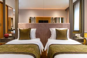 a hotel room with two beds and a mirror at Oran Hotel in Istanbul