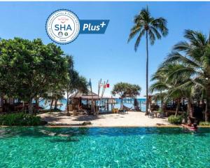 einen Pool in einem Resort mit einem Strand und Palmen in der Unterkunft Coco Lanta Resort - SHA Extra Plus in Ko Lanta