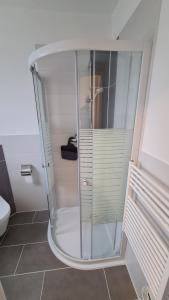 a shower with a glass door in a bathroom at Exzellentes Ferienhaus in Hannover Messe Nähe in Sarstedt +6 photos
