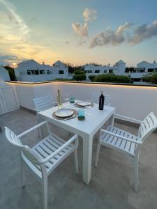 Una mesa blanca y dos sillas en un patio. en Izaro Apartamento Atico de Lujo cerca de Playa Dorada, en Playa Blanca
