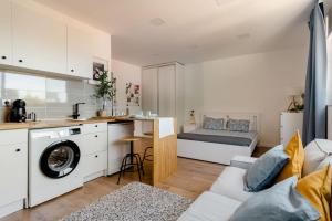 a living room with a couch and a kitchen with a washer at Stylish and Elegant Studio - Best View and Location in Coimbra Downton in Coimbra