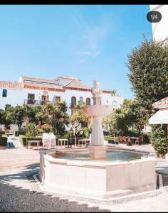 a fountain in a courtyard in front of a building at Apartamento Plaza de los Naranjos in Marbella