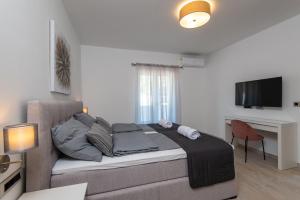 a bedroom with a bed and a desk and a television at Holiday Villa Olive Tree in Orebić
