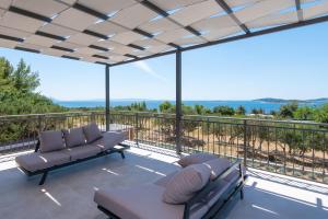 a patio with a couch and chairs on a balcony at Holiday Villa Olive Tree in Orebić