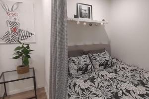 een slaapkamer met een bed met een zwart-wit dekbed bij Lemuria Apartament Szkolna centrum in Legnica
