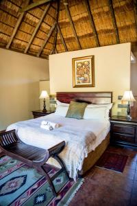 a bedroom with a large bed and a chair at Thaba Legae Guest Lodge in Rustenburg