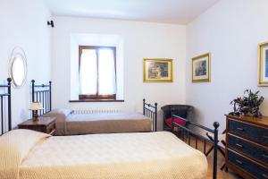 Agriturismo Cavalierino في مونتيبولسيانو: غرفة نوم بسريرين وخزانة