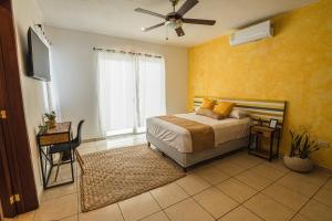 a bedroom with a bed and a ceiling fan at Casa Tulita Mérida in Mérida +36 photos