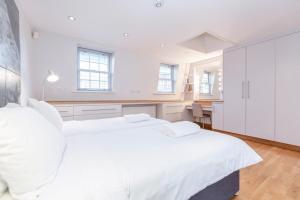 ロンドンにあるBeautiful 1 Bedroom Apartment in Victoriaの白いベッドルーム(ベッド2台、デスク付)