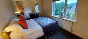 a bedroom with two beds and two windows at Hazel's House in Keighley