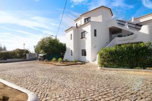 a white building on a cobblestone street at Apartamento Vila Mourisca in Porches
