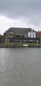 a house on the shore of a body of water at Waar Maas & Waal..... in Woudrichem