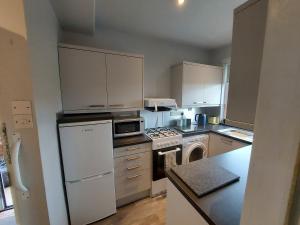 a kitchen with a white refrigerator and a stove top oven at Hazel's House in Keighley