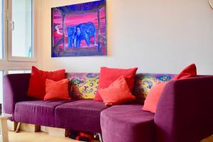 ブライトン＆ホーブにあるLovely 2 Bedroom Apartment with Balcony and Sea viewsの紫色のソファ(赤い枕付)が備わるリビングルーム
