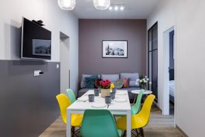 Friendhouse Residence في كراكوف: غرفة طعام مع طاولة وكراسي صفراء