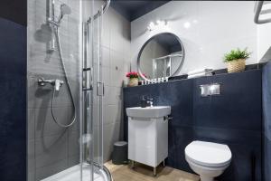 La salle de bains est pourvue d'une douche, de toilettes et d'un lavabo. dans l'établissement Friendhouse Residence, à Cracovie