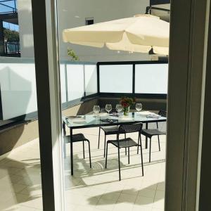 a table with chairs and wine glasses on a balcony at Magnolia Guest House Salerno in Salerno