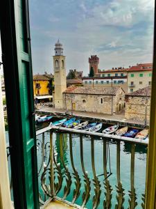 Aussicht von einem Balkon aus auf Boote in einem Hafen in der Unterkunft Oreste Suite in Lazise