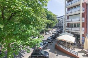 une rue avec des voitures garées dans un parking à côté d'un bâtiment dans l'établissement JANTAR APARTAMENTY -Port Kołobrzeg- Westerplatte z garażem, à Kołobrzeg