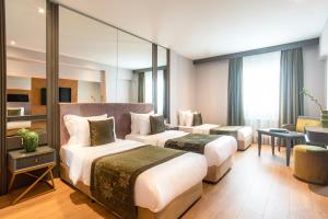 a hotel room with two beds and a mirror at Oran Hotel in Istanbul