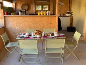 a table with chairs and a table with food on it at Château Ferrassières in Ferrassières