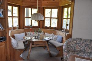 a living room with a table and chairs and windows at Ferienwohnung Andrea in Schleching